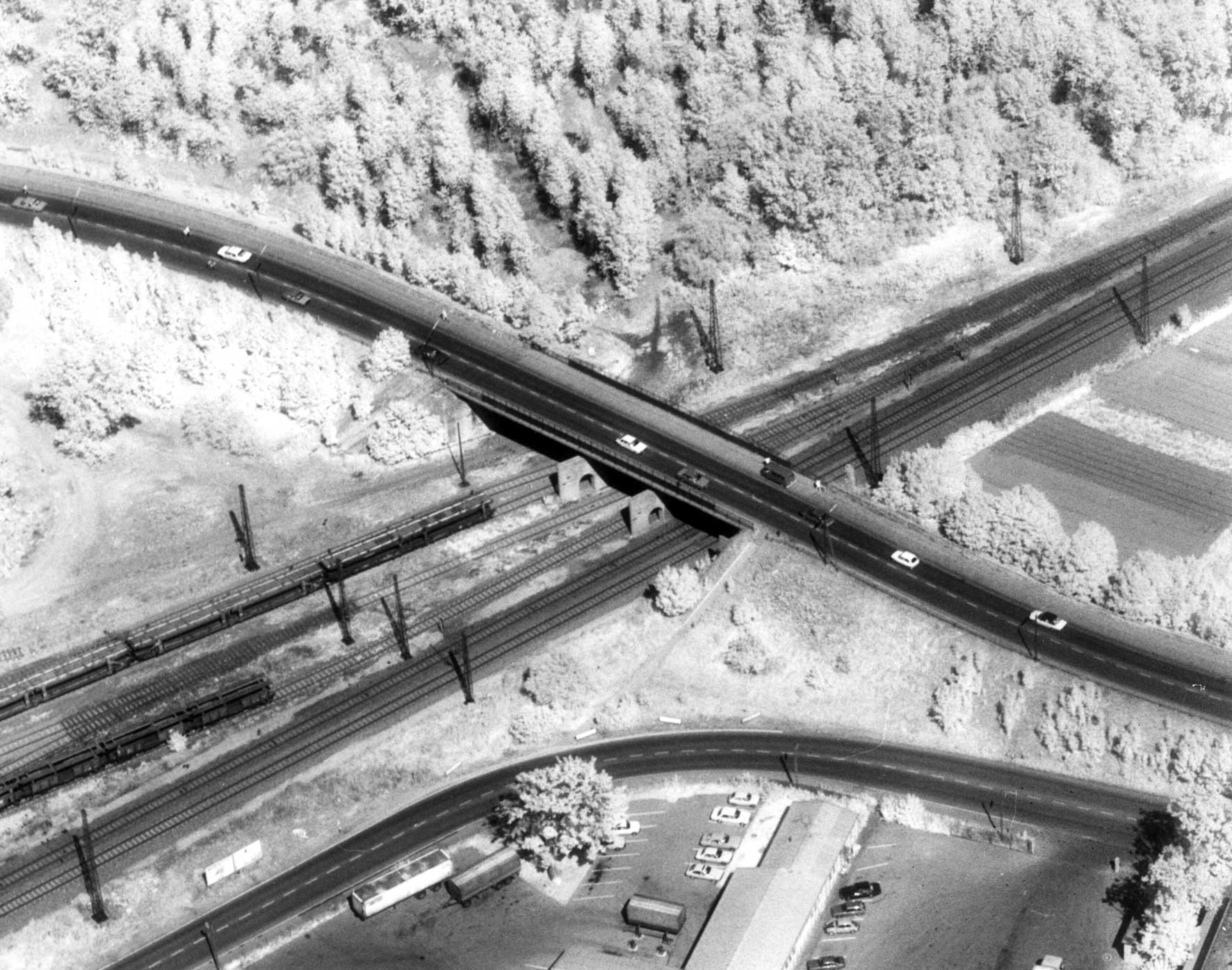 Die ungewohnte Infrarotfotografie 800nm (s/w) der Kreuzung mit der Eisenbahnstrecke zeigt das unterschiedliche Reflexions- und Absorbtionverhalten der verschiedenen Oberflächen Foto 1979, Karl Schillinger)