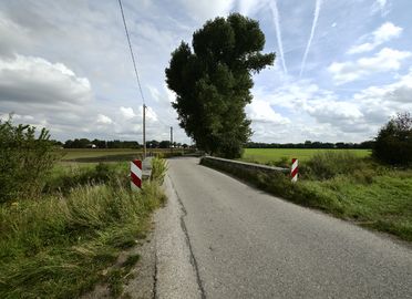 Die Salzstraße. Ein schmaler geteerter Feldweg an der Brücke über den Hüllgraben.