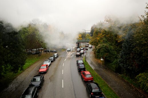 Der gegenüberliegende Blick am Übergang vom Dreimühlenviertel nach Sendling auf der Bahnbrücke unweit der Braunauer Eisenbahnbrücke am Südring. Über der Isartalstraße fällt der Blick auf das nicht mehr genuzte Überbrückungsbauwerk der ehemaligen Zulaufstrecke zur Isartalbahn. Hinter dem Dampf liegen die Schäftlarnstraße und Lagerhausstraße.
