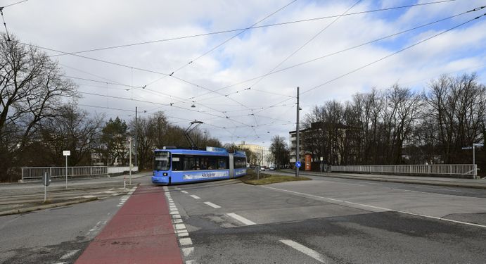 Das südwestliche Ende der Westendstraße. Die Straße wird hier über die A 96 geführt und verläuft noch ein kleines Stück zu den Parkplätzen am Westpark, als Sackgasse mit Wendeschleife, hinein. Der Hauptfluss des Straßenverkehrs wird bereits vor der Brücke zur linken Seite hin auf den Zubringer zur A 96 und der Fürstenrieder Straße abgeleitet. Die Trambahnen biegen hier zum Stegener Weg und weiter zum Gondrellplatz ab. Vor dem Bau der A 96 war der Stegener Weg Bestandteil der Westendstraße, die hier zur Fürstenrieder Straße führte. Die Westendstraße stellt derzeit mit der anschließenden Gilmstraße eine Verbindung mit der Ehrwalder Straße her. Bevor die Gilmstraße angelegt wurde, war dies der alte Verlauf, und um 1910, das Ende der Westendstraße.