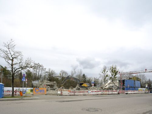 Bauarbeiten für die Tram Nordtangente am U-Bahnhof Kieferngarten. Abbruch des ehemaligen Parkhauses am Bus-Wendeplatz Kieferngarten. Im März 2026 ist das Gebäude nahezu abgeräumt.