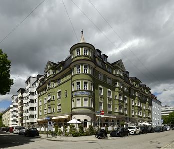 Viktoriastraße 23 bis 25. Wohn- und Geschäftshaus, viergeschossiger Mansarddachbau mit rundem Eckturm und Erkern, im barockisierendem Heimatstil, von Otto Steinbüchel, in den Jahren von 1927 bis 1932 errichtet.