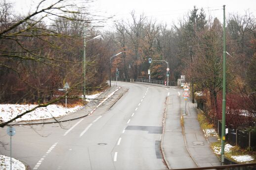 Die Menzinger Straße hinter der Bahnunterführung bei Obermenzing. Zur linken Seite geht die Donizettistraße ab. Diese war bis zum Umbau der Amalienburgstraße, im Jahr 1962, die eigentliche Verbindungsstraße zwischen der Verdistraße und der Menzinger Straße und auch Bestandteil der Verdistraße. Zustand Dezember 2011.