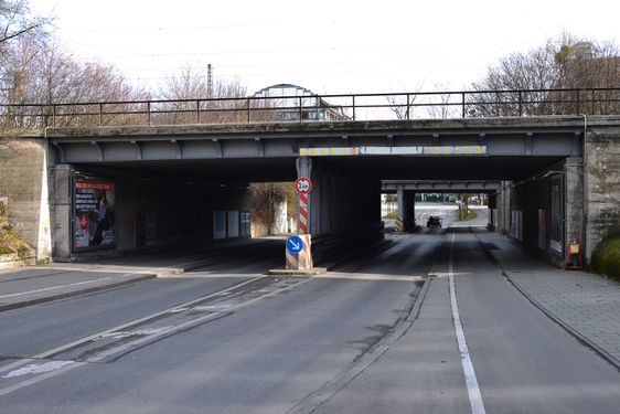 Blick auf die Westendstraße an der doppelt ausgeführten Bahnunterführung. Diese Unterfahrt wird erstmals ab dem Jahr 1899 bis 1903 errichtet. In die Hangmauer wurde eine Bedürfnisanstalt eingebaut. Türen und Fensteröffnungen sind mittlerweile zugemauert, aber noch erkennbar. Die Blickrichtung zur Schwanthalerhöhe. Hinter der Unterführung geht es rechts in die Ridlerstraße ab. Linker Hand zur Barthstraße, und leicht mittig versetzt weiter in die alte Westendstraße. Zustand Februar 2014.