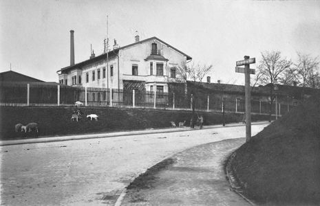 Ecke Friedenstraße und Berg-am-Laim-Straße im Jahr 1922. Einer der Lagerhallen der ehemaligen Münchener Lagerhaus und Transport G.m.b.H. Berg-am-Laim-Straße 33. Vormals Lagerhäuser Floßmann und Schmederer erstmals um 1872 am Platze. Das abgebildete Gebäude entstand zusammen mit anderen Bauten, Die Lagerhallen hatten dort unter der Firmengruppe Rhenania bestand bis in die 1980er-Jahre. Ein Teil des Grundstücks wurde 1965 an die Stadt verkauft, um die Verbindung zum Leuchtenbergring zu ermöglichen.