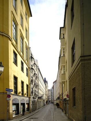 Von der Sparkassenstraße aus gesehen fällt der Blick durch die Falkenturmstraße hinunter bis zum Am Kosttor. Des gelb gestrichene Eckhaus, an der linken Seite Bildseite noch abgeschnitten sichtbar, kann als ehemaliger Standort des Falkenturms angesehen werden.