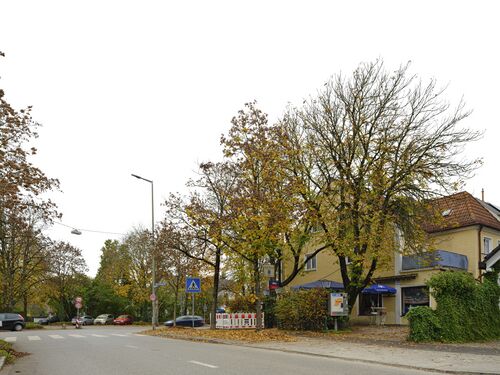 Situation entgegengesetzt. Gaststätte Gambrinus am Straßenrand. Beim Tempo-20-Schild führt die Allacher Straße, stark verkehrsberuhigt, zur Bahnunterfahrt hinüber.