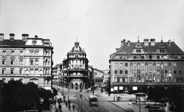 Rechte Bildseite - Hotel Königshof mit den in den Jahren 1880 bis 1885 erweitereten Umbauten und der von Johann Schraudolph gemalten Fassade. Bildmitte - Hotel Imperial aus dem Jahr 1881 - Das Bügeleisenhaus -, dazwischen Blick zum Hauptbahnhof, linke Seite das im Jahr 1873-1874 errichtete Hotel am Stachus. Zustand um 1887. Keines der Gebäude ist erhalten.
